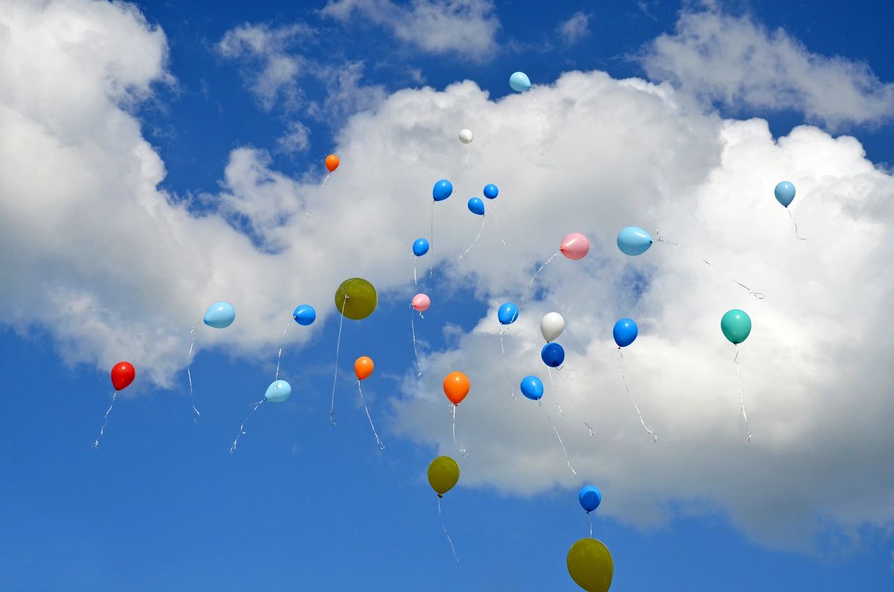 Colorful balloons floating against a bright blue sky — celebrating new beginnings