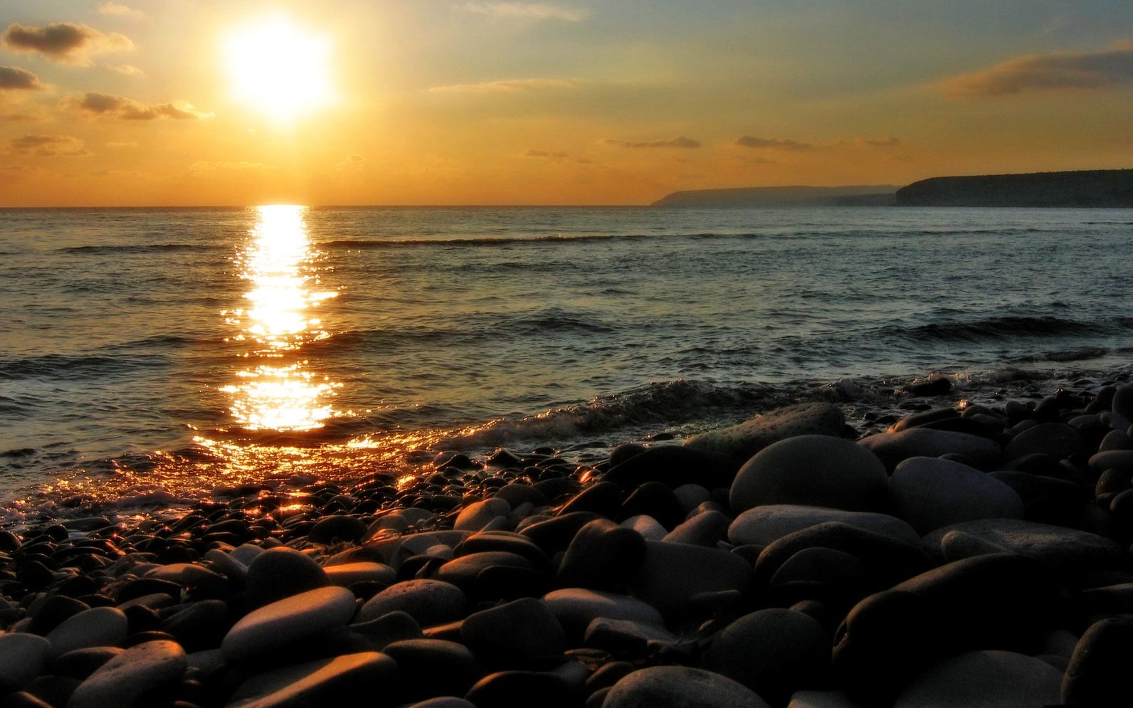 Coastal sunset with smooth stones